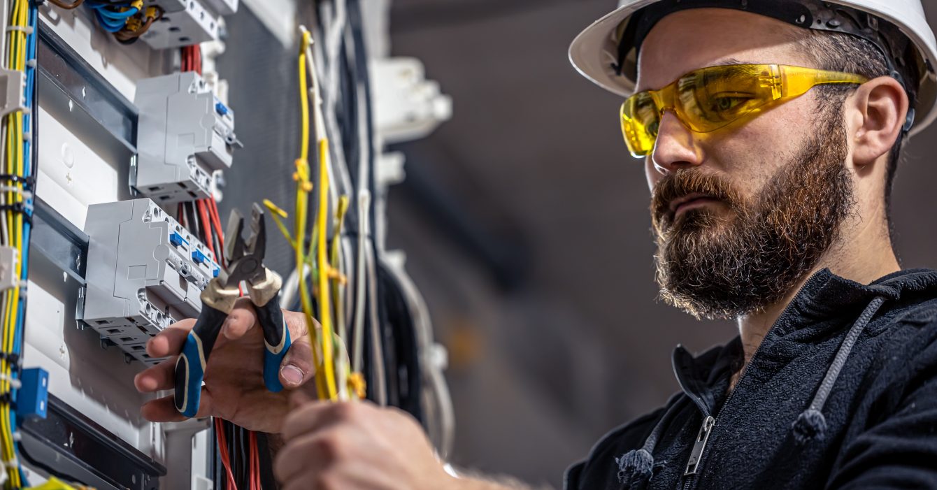 male-electrician-works-switchboard-with-electrical-connecting-cable.jpg